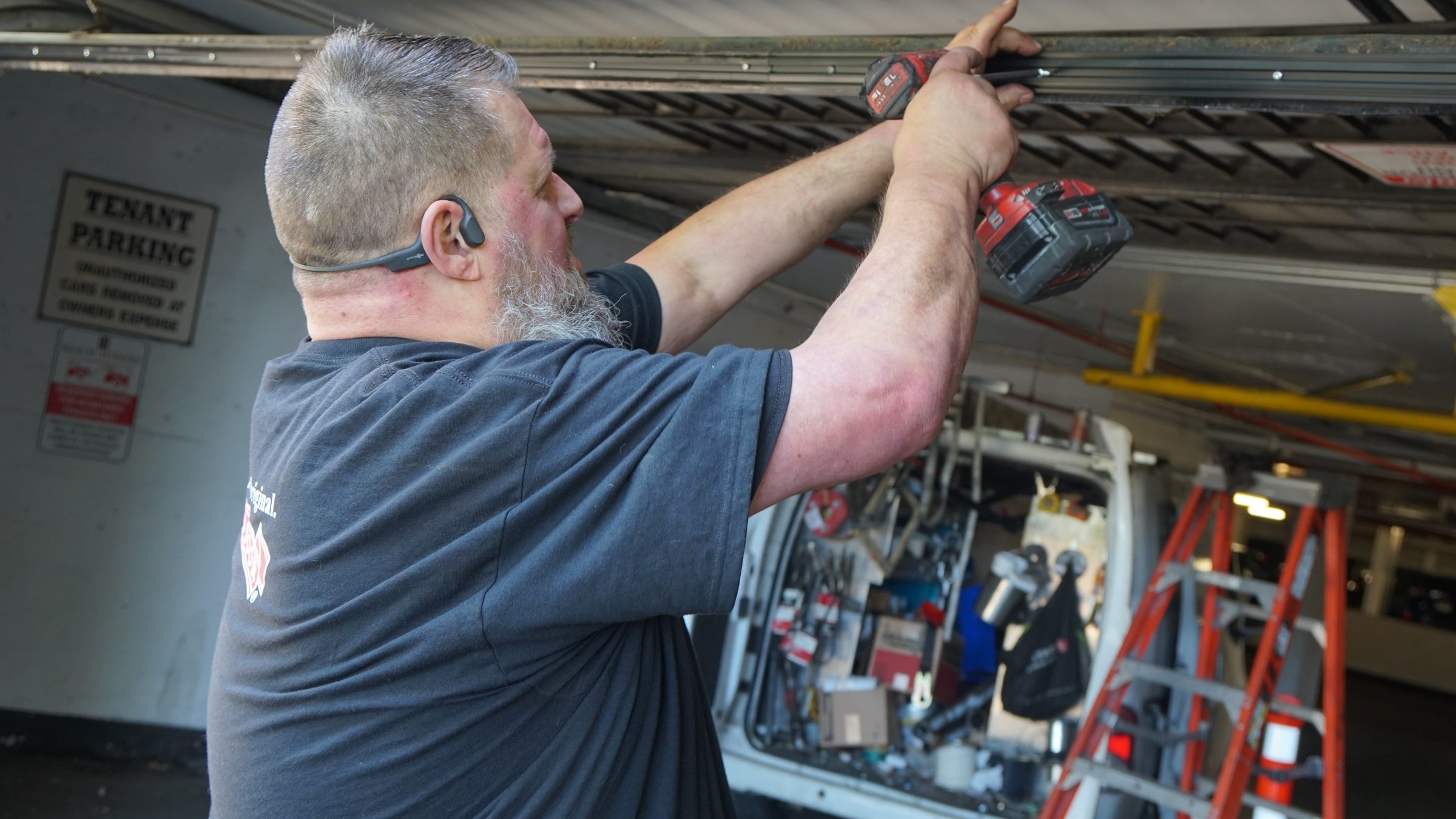 Technician servicing an overhead door track