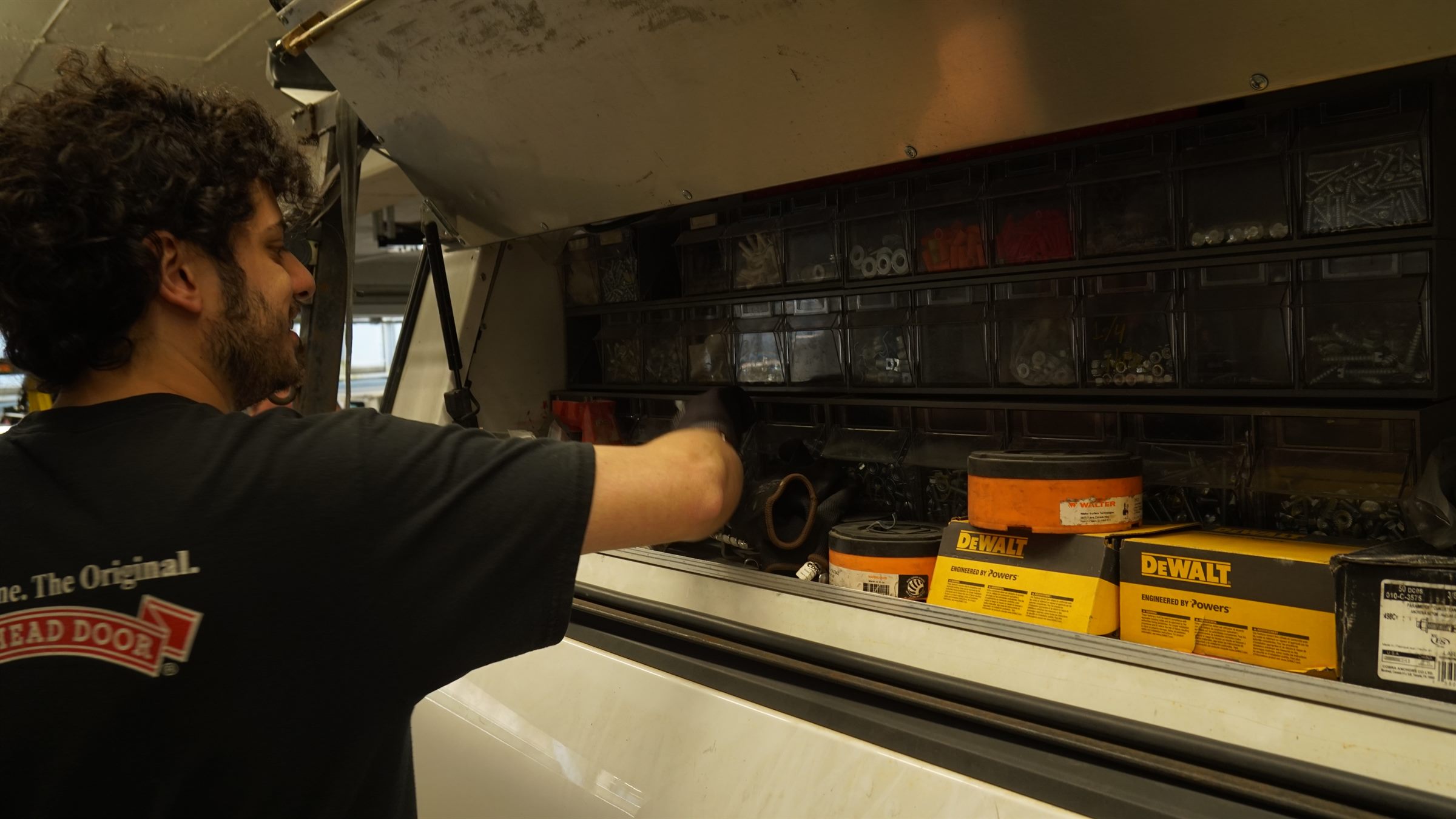 Technician pulling parts from a stocked service truck